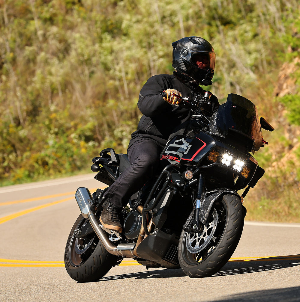 Rider cornering a Harley-Davidson Pan America fitted with a Stealth Pipes slip-on exhaust